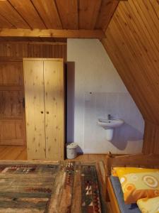 La salle de bains est pourvue d'un lavabo et d'un lit dans la chambre. dans l'établissement Pokoje Regle 30, à Zakopane