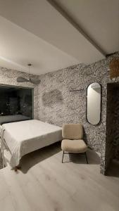 a bedroom with a bed and a chair at Apartment Sarajevo Calling - Free parking in Sarajevo