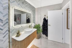a bathroom with a sink and a mirror at Brand New Gold Coast Luxury Retreat in Mudgeeraba +29 photos