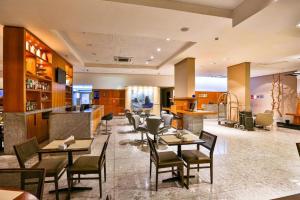 ein Restaurant mit Tischen und Stühlen und eine Bar in der Unterkunft Beach Class Executive - Boa Viagem in Recife