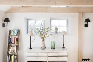 a living room with two lamps and a dresser at Urgemütliche Reetdachkate mit großem Kamin und Sauna in Pommerby