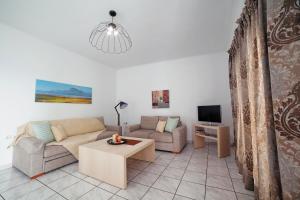 - un salon avec un canapé et une table dans l'établissement Minos Apartments & Studios, à Siteía