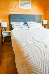 a large white bed with a blue headboard in a room at Nowy domek z podgrzewanym basenem na wyłączność in Braniewo +50 photos