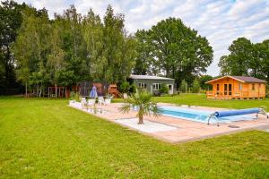 a swimming pool in a yard with a house at Nowy domek z podgrzewanym basenem na wyłączność in Braniewo