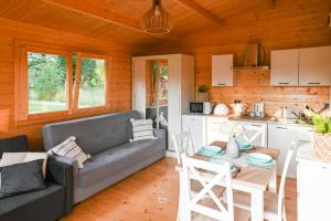 a living room with a couch and a table and a kitchen at Nowy domek z podgrzewanym basenem na wyłączność in Braniewo