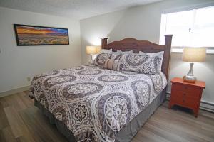 Un dormitorio con una cama y una mesita de noche con una lámpara. en Hot Tub, Beautiful Mountain Views, 3 Bedroom Plus Loft, en Steamboat Springs