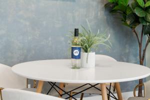 een fles wijn op een witte tafel met een plant bij 2 Bed & 3 Bath Chicago Condo in Chicago