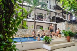 a group of people sitting in a swimming pool at Departamentos en SF - Adults Only in Playa del Carmen
