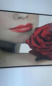 a woman with red lipstick holding a red rose at Hostal Buenos Aires in Madrid