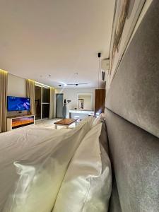 a bedroom with a large white bed and a living room at radhwan chalet رضوان شالية in Qurayyah