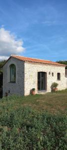 a stone house with two plants in a field at La Haute Combe in Liré