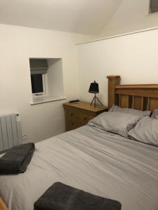 a bedroom with a bed and a dresser with a television at Old chemist in Lybster