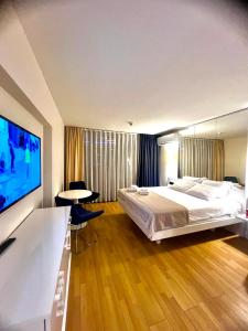 une chambre avec un grand lit et une télévision à écran plat dans l'établissement Orbi city apartment, à Batoumi