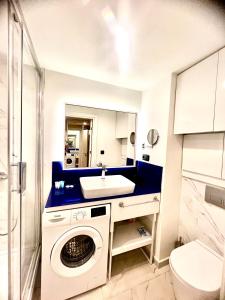 une salle de bains avec lave-linge et lavabo dans l'établissement Orbi city apartment, à Batoumi