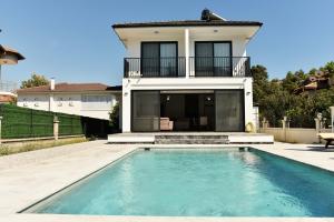 a house with a swimming pool in front of a house at Villa Sarisli 2 in Ortaca +10 photos
