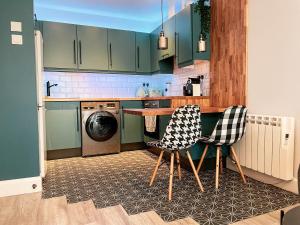a kitchen with green cabinets and a table and chairs at Modern apartment 10min from City Center with parking in Dublin +7 photos