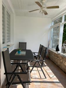a dining room table with four chairs and a ceiling fan at Sea Star in Neum