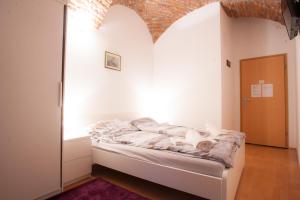 1 dormitorio con 1 cama en una pared blanca en Guest House Nokturno, en Zagreb