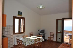 a dining room with a table and chairs and a television at Villa Bella Vista in Capo Vaticano