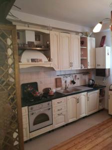 Una cocina con gabinetes blancos y un horno de estufa. en Отличный отдых в центре Батуми, en Batumi