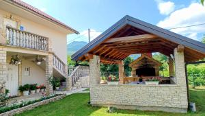 a patio with a stone fireplace in a house at Apartman Šimić in Gračac
