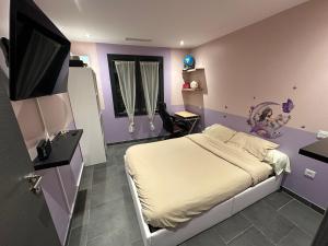 ein Schlafzimmer mit einem Bett und einem Fernseher in der Unterkunft Maison Isle sur la sorgue in LʼIsle-sur-la-Sorgue