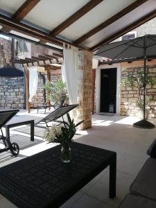 a patio with a table and an umbrella at Lory in Sveti Lovreč Pazenatički