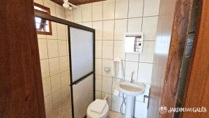 a bathroom with a toilet and a sink at Jardim das Gales Bombinhas in Bombinhas +117 photos