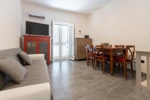 a living room with a couch and a dining room table at Light stadium in Taormina