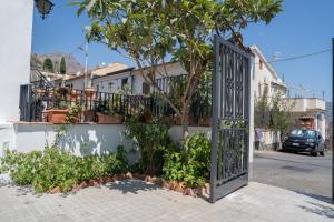 an open gate with a tree in front of a house at Light stadium in Taormina