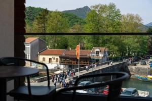 a group of people walking on a bridge over a river at Hotel De‘Andros Virpazar in Virpazar