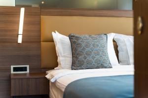 a bedroom with a bed with a wooden head board at Hotel De‘Andros Virpazar in Virpazar
