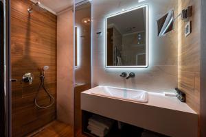 a bathroom with a sink and a mirror and a shower at Hotel De‘Andros Virpazar in Virpazar