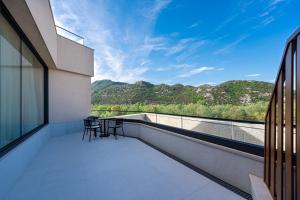 a balcony with chairs and a view of mountains at Hotel De‘Andros Virpazar in Virpazar