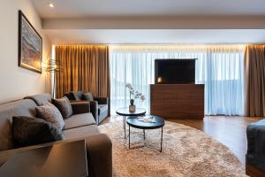 a living room with a couch and a tv at Hotel De‘Andros Virpazar in Virpazar
