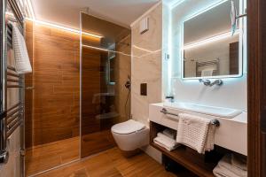 a bathroom with a shower and a toilet and a sink at Hotel De‘Andros Virpazar in Virpazar