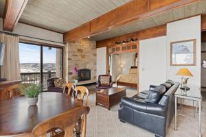 a living room with a table and a bedroom at Storm Meadows Club A-219, Corner Unit, Amazing Panoramic Views, Ski In Ski Out, Club Amenities in Steamboat Springs