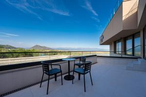 a balcony with a table and chairs on a building at Hotel De‘Andros Virpazar in Virpazar