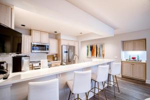 una cocina con armarios blancos y taburetes blancos en Peaceful Lakefront Beauty (D105), en Harrison