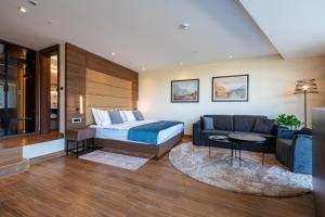 a hotel room with a bed and a couch at Hotel De‘Andros Virpazar in Virpazar