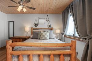a bedroom with a wooden bed and a ceiling fan at Ski In, Ski Out, Steam Shower in Unit, Outdoor Hot Tub in Steamboat Springs