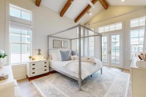 a bedroom with a canopy bed in a room with windows at Palmilla Beach Sunrise Dreams in Port Aransas