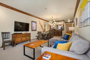 a living room with a couch and a table at Snow Flower 204 -REDUCED RATES- Pool, Hot Tub, Balcony with Views, Steps to Gondolas, Restaurants in Steamboat Springs +32 photos