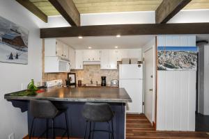 a kitchen with white cabinets and a large counter top at Heated Pool, Private Washer & Dryer, Ski In, Ski Out, Just Remodeled in Steamboat Springs