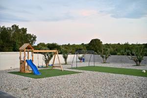 a playground with a slide and a swing at Villa Donatus in Murvica