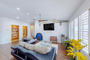 a living room with a couch and a tv at Valparaiso Desert Paradise in Desert Hot Springs