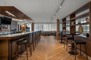 a bar with black stools in a restaurant at DoubleTree by Hilton Kingston - Newly Renovated in Kingston