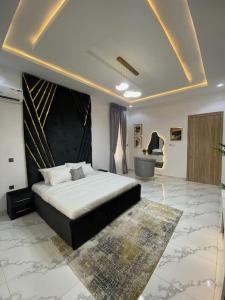 une chambre avec un grand lit et une chaise dans l'établissement Luxury Two Bedroom Apartment, Lekki, à Lekki