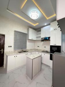 une cuisine avec des placards blancs et un plafond dans l'établissement Luxury Two Bedroom Apartment, Lekki, à Lekki