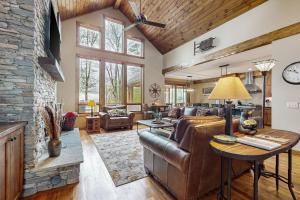 a living room with a leather couch and a stone fireplace at Sunset Vista at Monteagle in Banner Elk